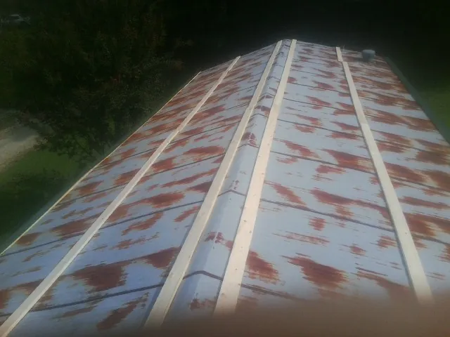 Rusted metal roof panels with new wood purlins before replacement — Storm Damage Roof Repair in Carey by Roofing Brothers