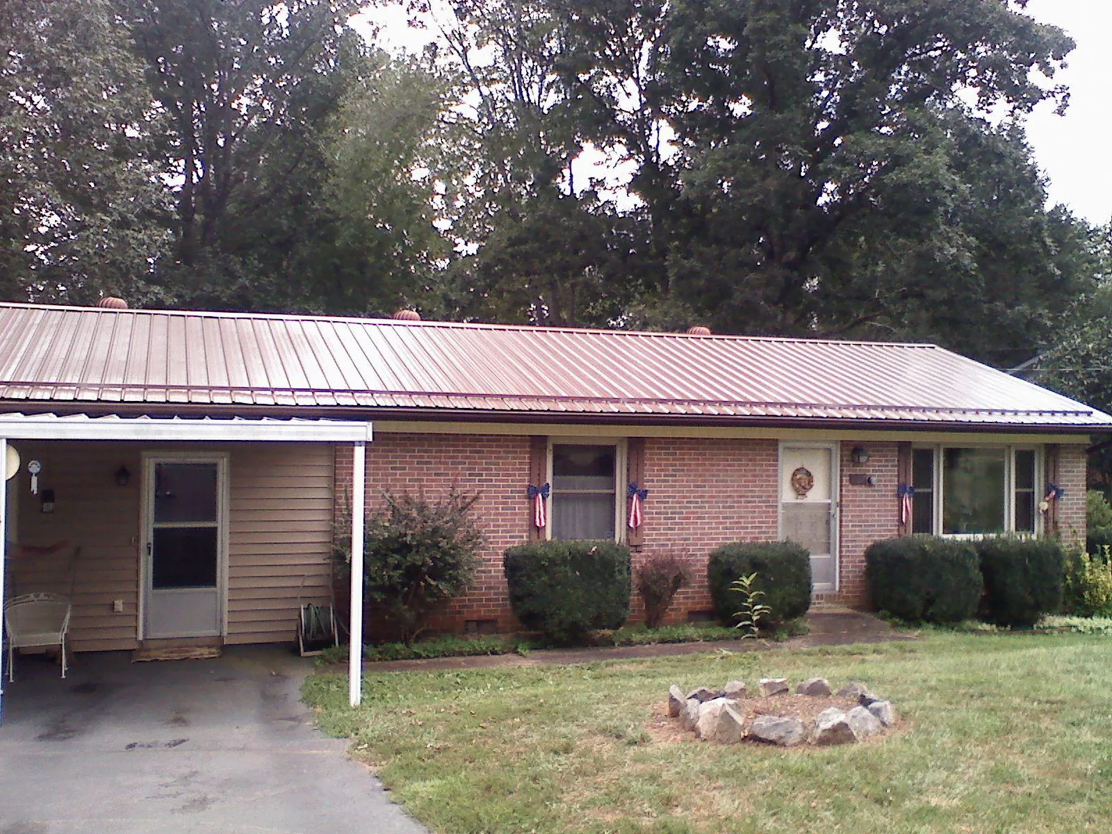 Bronze metal roof and carport on a brick ranch home — Roof Repair work by our crew in Carey